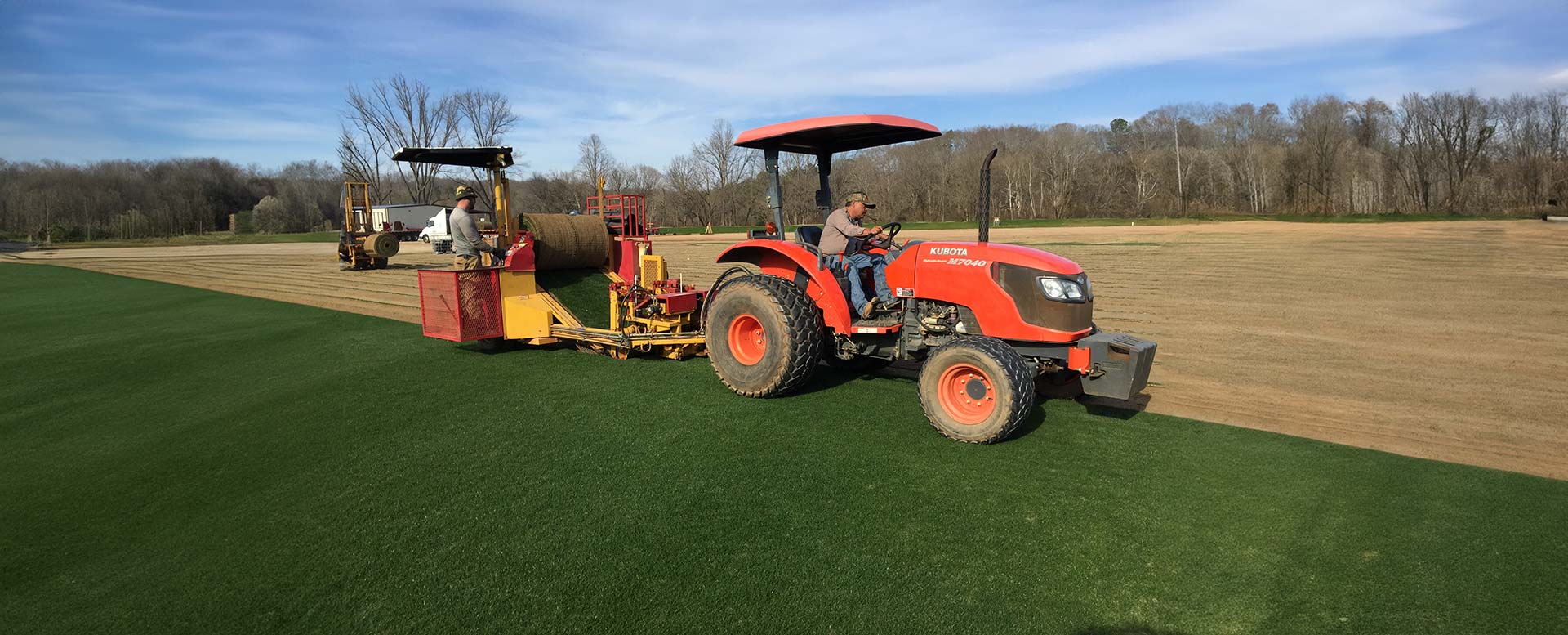 An employee for Precision Turf, operates an orange tractor who applied for careers for turf construction.